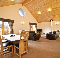 A living room with a dining area and seating at Osprey Spa Plus in Dundee