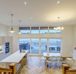A kitchen with a dining area and large windows at Lochside Premier Spa in Dundee