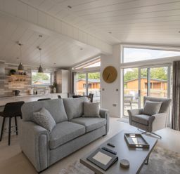 A living room with a sofa and kitchen area at The Luxury Hideaway in Waltham