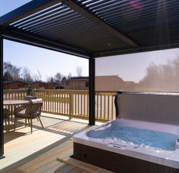 An outdoor deck with a hot tub and seating at The Luxury Hideaway in Waltham