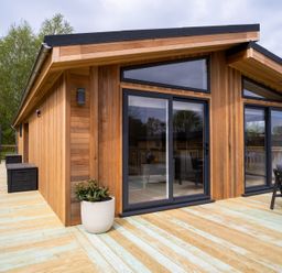 A wooden exterior with large windows and decking at The Luxury Hideaway in Waltham