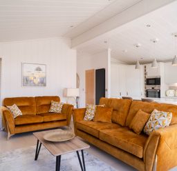 A living room with orange sofas and a coffee table at Luxurious Serenity in Waltham