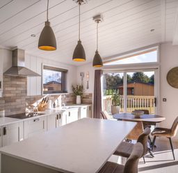 A kitchen with an island and dining table at Luxurious Serenity in Waltham