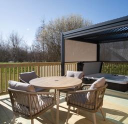 A patio with outdoor furniture and a jacuzzi at Luxurious Serenity in Waltham