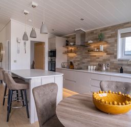 A kitchen with a dining table and modern appliances at The Luxury Escape in Waltham