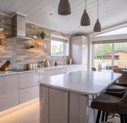 A kitchen with modern appliances and a window overlooking a patio at The Luxury Escape in Waltham