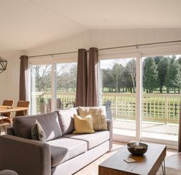 A living room with a sofa and dining area at Dovecote in Waltham