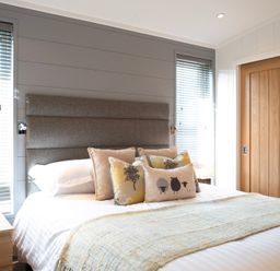 A bedroom with a bed and decorative pillows at Dovecote in Waltham