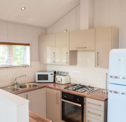 A kitchen with a sink, microwave, toaster and refrigerator at The Henley in Waltham