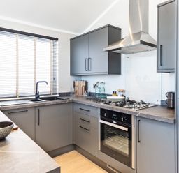 A kitchen with grey cabinets and appliances at Shangri-La in Waltham