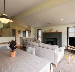 A living room with a fireplace and television at Macosi in Waltham