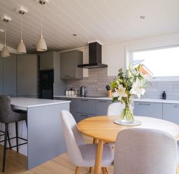 A kitchen with an island and dining area at The Luxury Retreat in Waltham