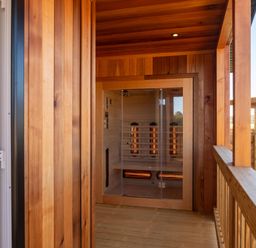 A sauna with wooden walls and a glass door at Exclusive Aura Spa in Waltham