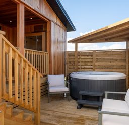 An outdoor area with a hot tub and seating at Exclusive Aura Spa in Waltham