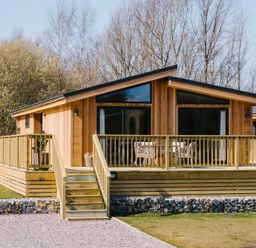 A wooden cabin with a deck and stairs at Marrakech in Waltham