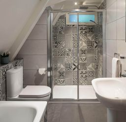 A bathroom with a shower, bathtub, toilet, and sink at St Ives Lodge 2 Spa in Praze-An-Beeble