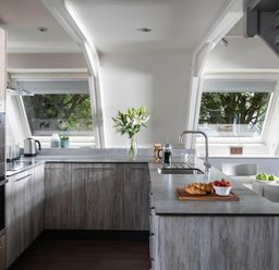 A kitchen with cabinets and a table with food at St Ives Lodge 2 Spa Praze-An-Beeble