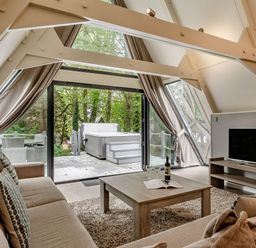 A living room with a sofa and table at St Ives Lodge 3 Spa in Praze-An-Beeble