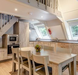 A kitchen with a dining table and chairs at St Ives Lodge 3 Spa in Praze-An-Beeble