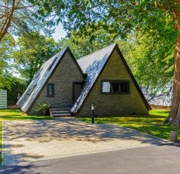A house with a pitched roof and a paved driveway at Glass Lodge in Praze-An-Beeble