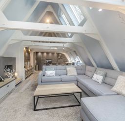 A living room with a sofa and coffee table at Glass Lodge in Praze-An-Beeble