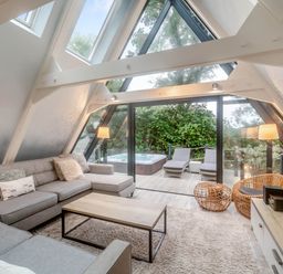 A living room with a sofa and coffee table at Glass Lodge in Praze-An-Beeble