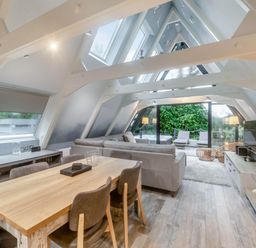 A living room with a sofa and dining table at Glass Lodge in Praze-An-Beeble