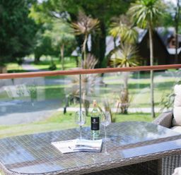 An outdoor seating area with a table and drinks at Aubyn Lodge Spa in Praze-An-Beeble