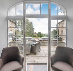 A dining area with chairs and a view of the patio at Coach House Praze-An-Beeble