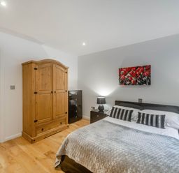 A bedroom with a bed and wardrobe at Cornwall Lodge Spa in Praze-An-Beeble