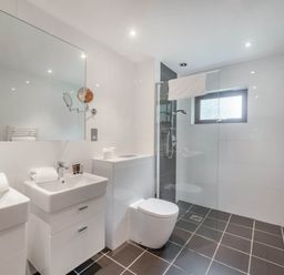 A bathroom featuring sinks, a toilet, and a shower at Cornwall Lodge Spa in Praze-An-Beeble