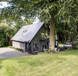 A house with a balcony and garden at St Austell Lodge Spa in Praze-An-Beeble