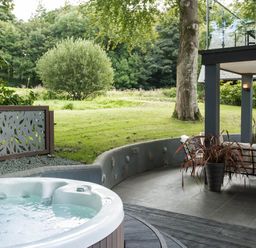 An outdoor area with a hot tub and seating at St Austell Lodge Spa in Praze-An-Beeble