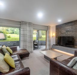 A living room with a sofa and television at St Austell Lodge Spa in Praze-An-Beeble