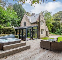 An outdoor area with a hot tub and seating at The Gatehouse in Praze-An-Beeble