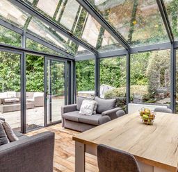 A conservatory with seating and a table at The Gatehouse in Praze-An-Beeble