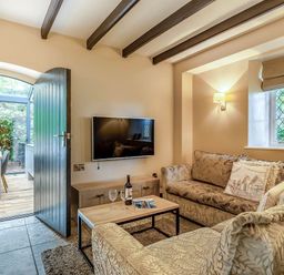 A living room with a sofa and a television at The Gatehouse in Praze-An-Beeble