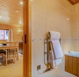 A dining room with a table and chairs at Woodland Lodge Spa in Praze-An-Beeble