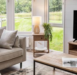 A living room with a sofa and lamp at Lake View Spa in Praze-An-Beeble