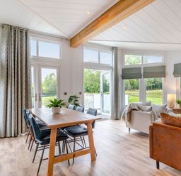 A living room with a table and chairs at Lake View Spa in Praze-An-Beeble
