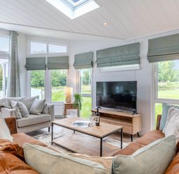 A living room with a sofa and a television at Lake View Spa in Praze-An-Beeble