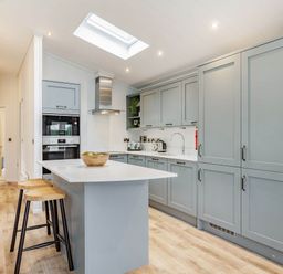 A kitchen with a central counter and stools at Lake View Spa in Praze-An-Beeble