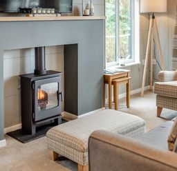 A living room with a fireplace and seating area at Argel Spa in Praze-An-Beeble