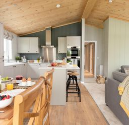 A kitchen with a dining table and sofa at Argel Spa in Praze-An-Beeble