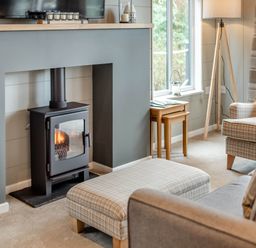 A living room with a fireplace and television at Argel in Praze-An-Beeble