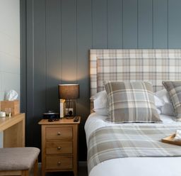 A bedroom with a bed, nightstand, and mirror at Argel in Praze-An-Beeble