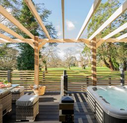 A garden with outdoor seating and a hot tub at Lowarth Lodge Spa Pet Praze-An-Beeble