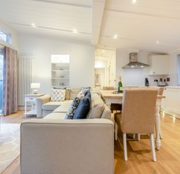 A living room with a sofa and dining area at Milk Wood 2 in Laugharne