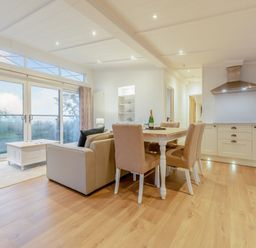 A living room with a dining area and kitchen unit at Milk Wood 2 in Laugharne