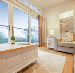 A living room with a coffee table and champagne on display at Milk Wood 2 in Laugharne